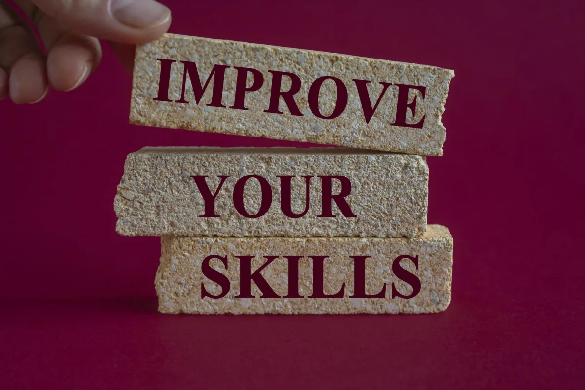 confidence is a skill — Improve your skills symbol Concept word Improve your skills written on the brick blocks Beautiful red background Businessman hand