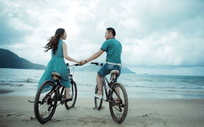 Couple riding a bike by the sea shore