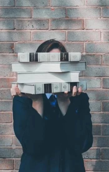 Woman holding stack of books