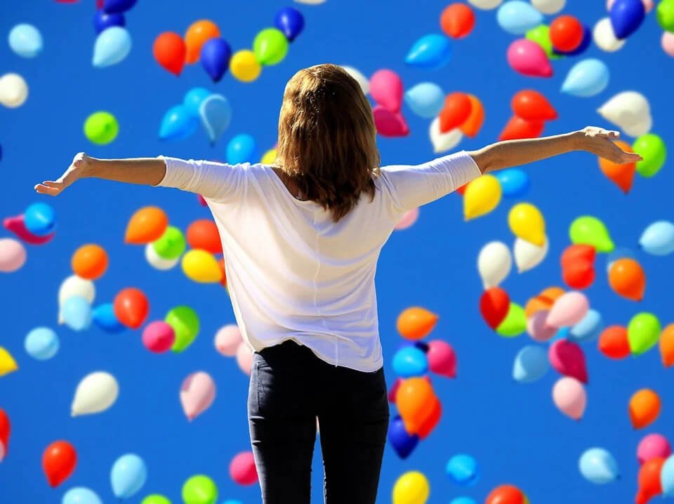 woman celebrating with a lot of balloons - Why confidence is important