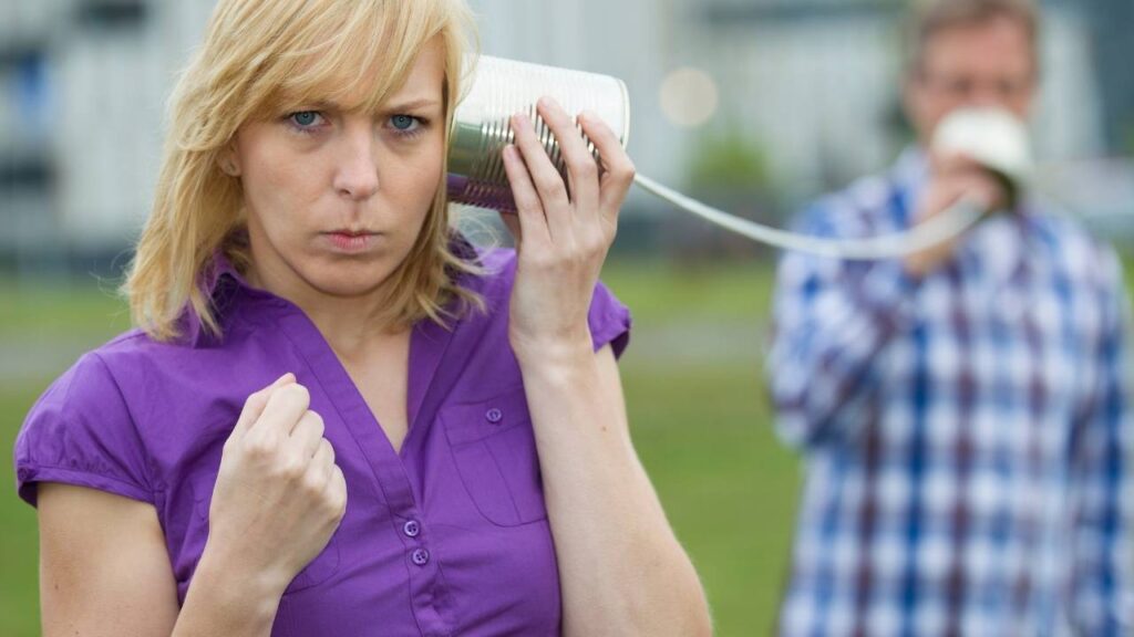 Man talking to a woman using 2 connected cans - Barriers to interpersonal communication