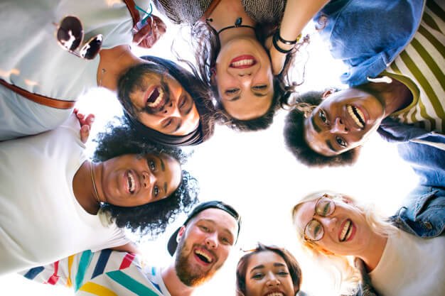 Group of people huddled together - how to develop a positive mental attitude