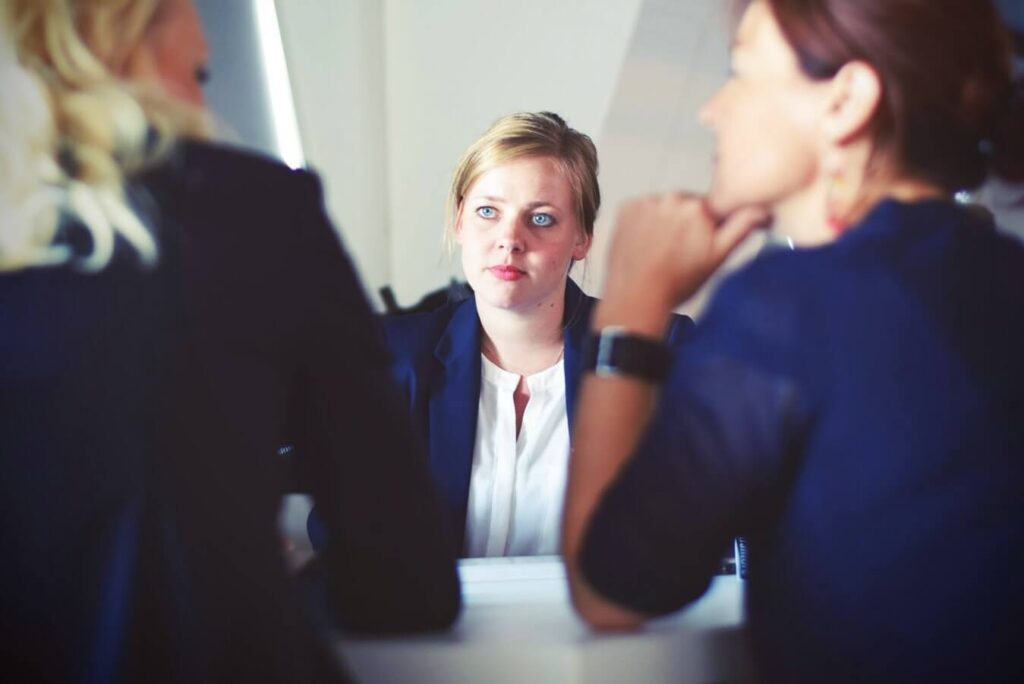 three women talking to each other - Awkward questions to ask people