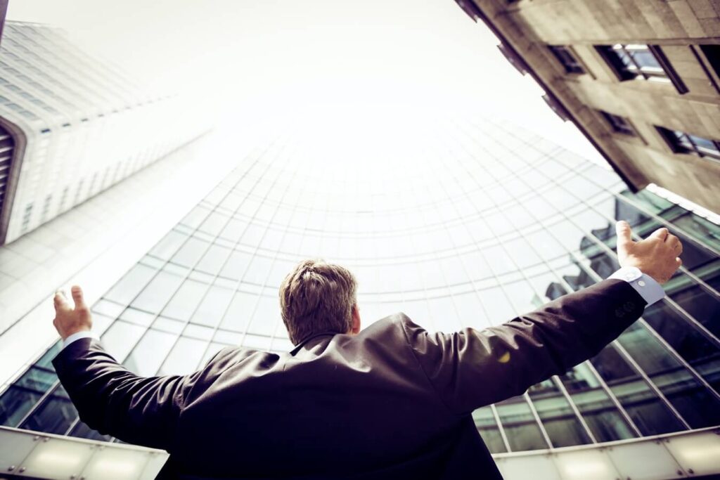 Man in a suit raising his hands in the air - How to deal with failure