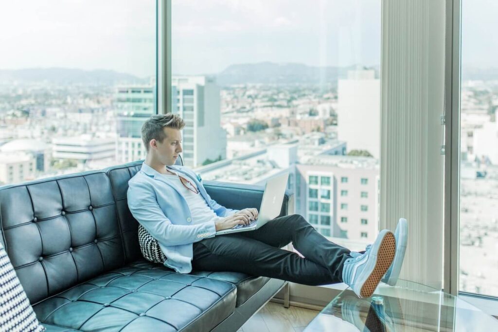 Man sitting on the sofa while using laptop - Personal and professional development