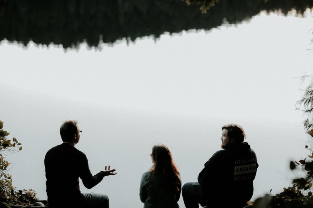 A group of people talking beside a lake - how confidence affects communication