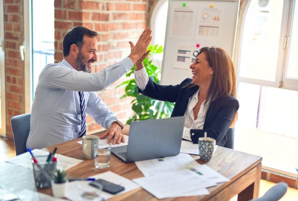 Coworkers high fiving - interpersonal and group communication