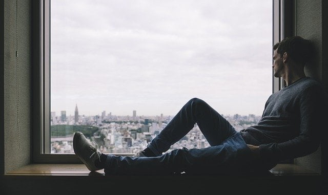 Man laying down and looking outside the window